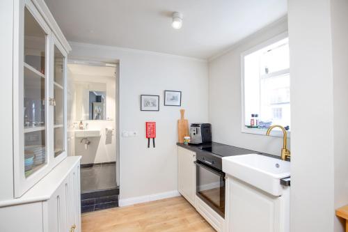 a white kitchen with a sink and a counter at Live as Locals Apartments in Reykjavík