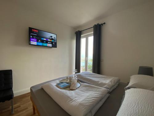 Schlafzimmer mit einem Bett und einem TV an der Wand in der Unterkunft Alpinlake Lodge & Wellness in Bosentino