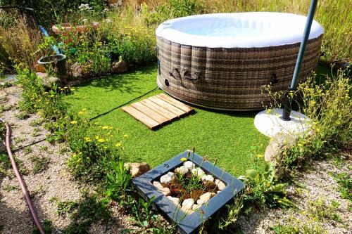 une baignoire installée à côté d'un jardin avec un planteur dans l'établissement La Ferme De Chenevier, La Roulotte Fleurie 2/4pers, à Saint-Victor