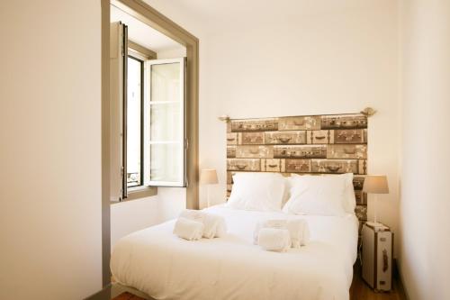リスボンにあるTrendy and Super Central Apartment 21 by Lisbonne Collectionのベッドルーム(大きな白いベッド1台、窓付)