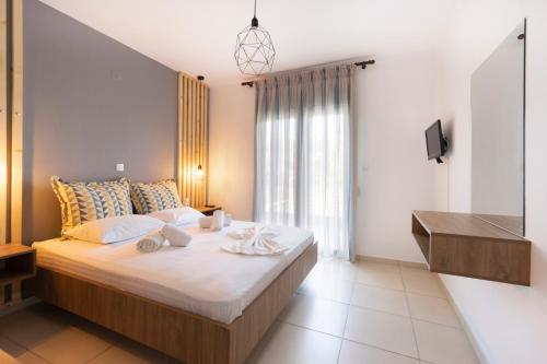 ein Schlafzimmer mit einem großen Bett und einem TV in der Unterkunft SK Suites Thassos in Skala Potamias