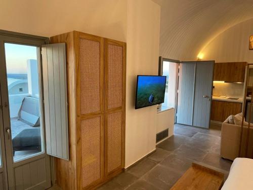 a living room with a tv on a wall at Anemi Vine Villas in Foinikiá