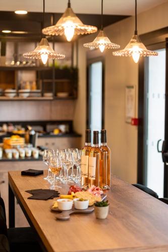 a table with two bottles of wine and glasses at Kyriad Hotel Laval in Laval
