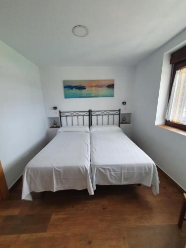 1 dormitorio con 2 camas con sábanas blancas y ventana en VADOS - LA COLINA, en Arnuero