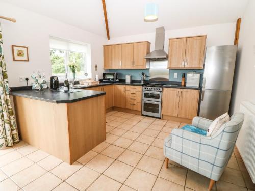 a kitchen with wooden cabinets and a counter top at Dinas Farmhouse Annex in Caernarfon