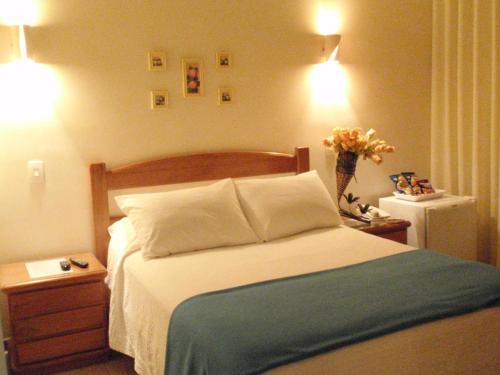 a bedroom with a bed and a vase of flowers at Pousada Sossego da Pampulha in Belo Horizonte