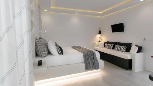 a white bedroom with a bed with pillows on it at Kamvas Deluxe Apartments in Naxos Chora