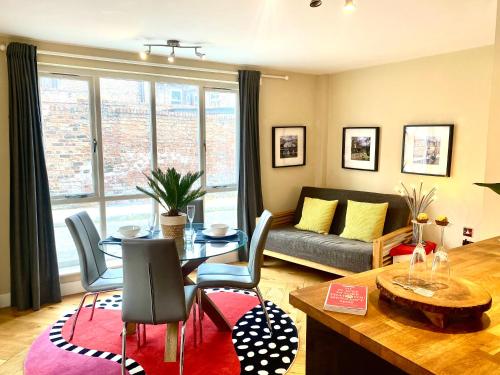 ein Wohnzimmer mit einem Tisch und einem Sofa in der Unterkunft Easy Walk City Centre Flat with Free Parking in York