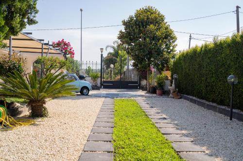 a garden with a car parked in a driveway at Paradise Sicily Rooms in Calatabiano