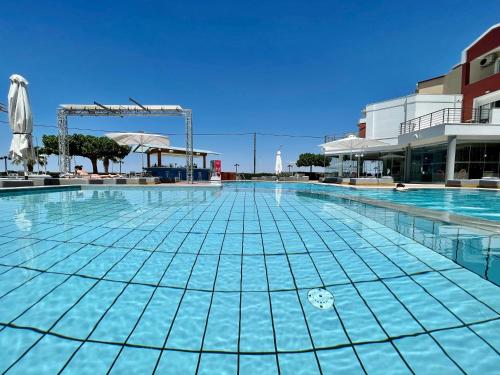 a large swimming pool with blue water at Heliotrope Hotels in Mytilini