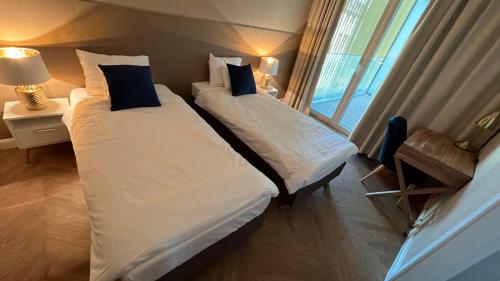 2 łóżka w pokoju hotelowym z oknem w obiekcie Apartament Powiśle Deluxe w Warszawie
