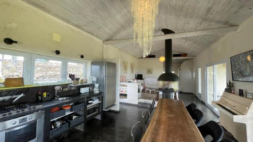 a large kitchen with a long wooden table in it at Casa Atlantida - Sea front in Faja Grande