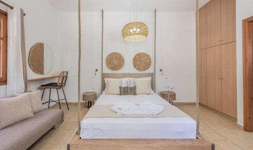 1 dormitorio con cama blanca y sofá en Mantelena studios & family apartments, en Pollonia