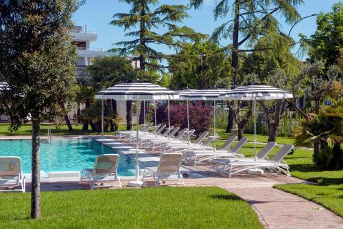 a row of chairs and umbrellas next to a pool at Hotel Premiere Abano in Abano Terme