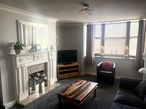 a living room with a fireplace and a tv at Seafront, Cleethorpes apt’s in Cleethorpes