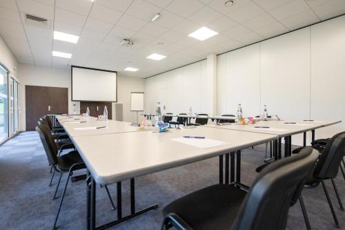 a conference room with a large table and chairs at Kyriad Hotel Laval in Laval