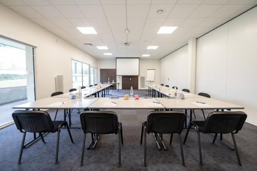 a large conference room with a large table and chairs at Kyriad Hotel Laval in Laval