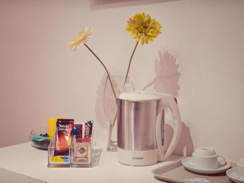 a coffee maker with a vase with a yellow flower in it at B&B Sul Corso in Salerno