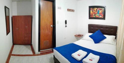 Un dormitorio con una cama azul y blanca y una puerta de madera en CASA HOTEL VICTORIA Av 30, en Bogotá