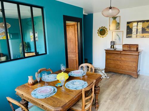 een eetkamer met een houten tafel en stoelen bij L'Emerald - Etretat in Étretat