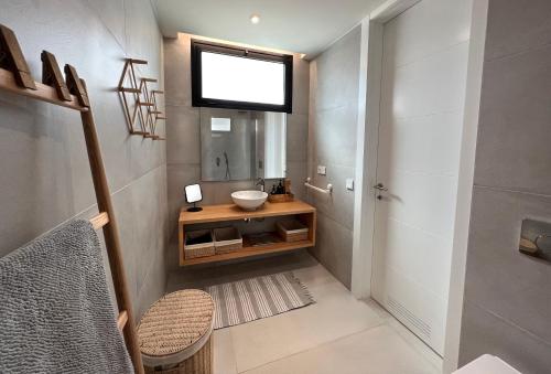 ein kleines Bad mit einem Waschbecken und einem Spiegel in der Unterkunft 3 bedrooms, spacious apartment 60 m from the beach in El Médano