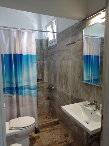 a bathroom with a white toilet and a sink at Boutique Pelayo in Leptokarya