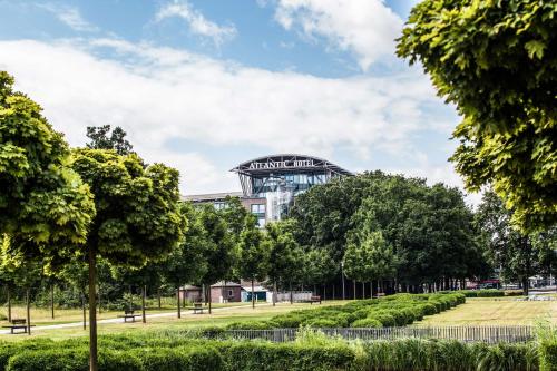 a park with trees and a bridge at Atlantic Hotel Airport in Bremen