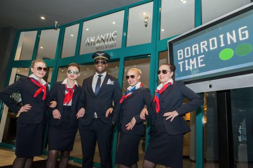 a group of people in suits standing in front of a building at ATLANTIC Hotel Airport in Bremen