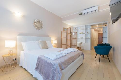 a bedroom with a white bed and a blue chair at Milan Retreats Duomo Suites in Milan