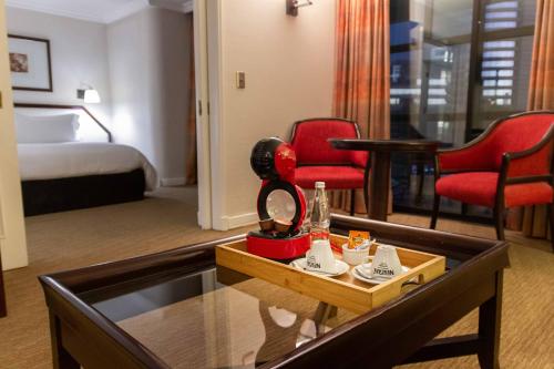 a hotel room with two red chairs and a table at Wyndham Garden Santiago Kennedy in Santiago