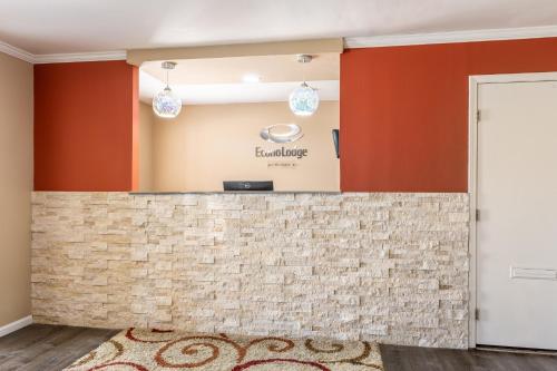 a lobby with a tile counter with the excellence sign on the wall at Econo Lodge in Concordia