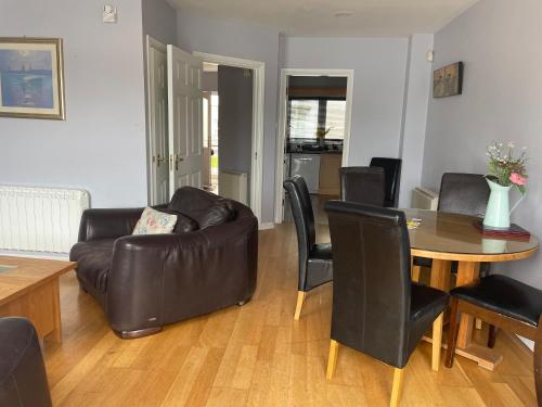 - un salon avec un canapé en cuir et une table dans l'établissement Five bedroom waterfront house, à Carrick-on-Shannon