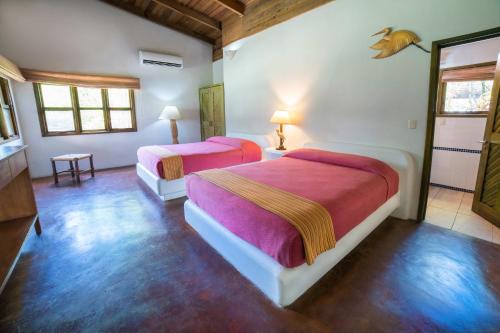 a bedroom with two beds in a room at Nanajuana Río Dulce in Río Dulce