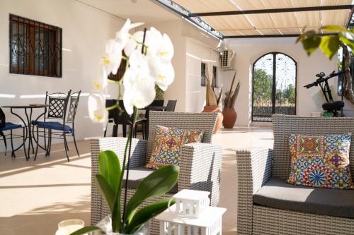 a living room with two wicker chairs and a table at Paradise Sicily Rooms in Calatabiano