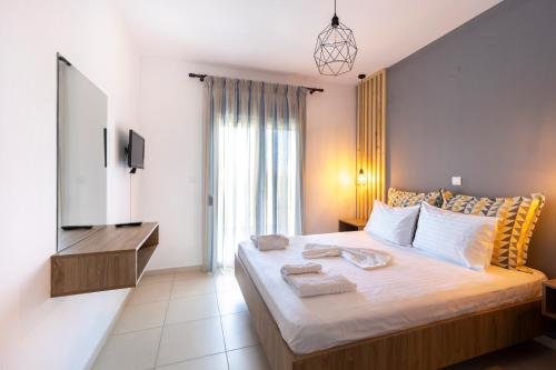 a bedroom with a large bed with towels on it at SK Suites Thassos in Skala Potamias