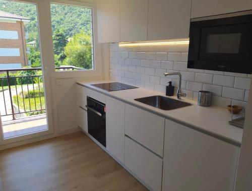 a kitchen with a sink and a tv on a counter at URDAIBAI HOME, cerca de la playa in Busturia
