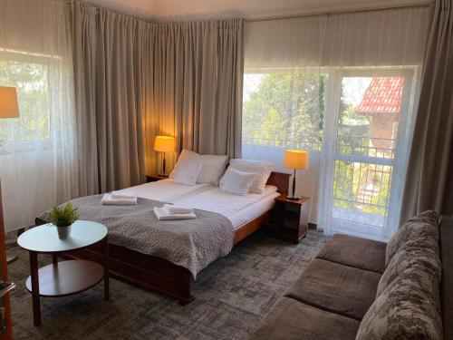 a bedroom with a large bed and a couch at Oaza Resort in Stegna