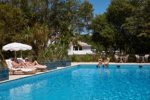 un groupe de personnes assises dans une piscine dans l'établissement Brindos, Lac & Château - Relais & Châteaux - Anglet Biarritz, à Anglet
