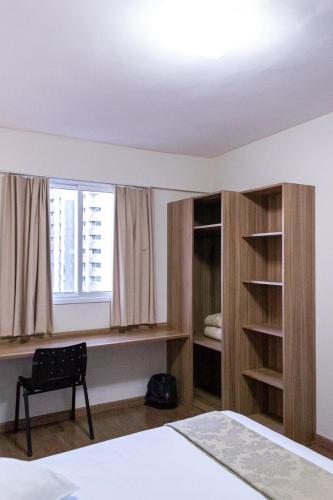 a bedroom with a bed and a window at Hotel Malibu Inn Campinas in Campinas
