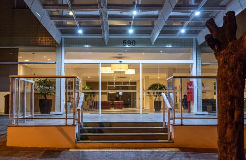 a lobby of a building with stairs in front at Hotel Malibu Inn Campinas in Campinas