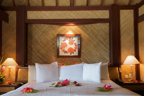 a bed in a hotel room with flowers on it at Maitai Bora Bora in Bora Bora
