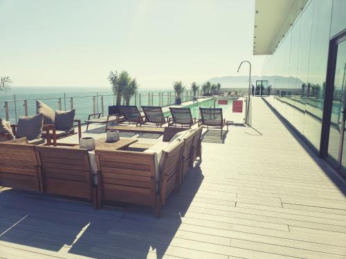 a deck with chairs and tables on a building at Hotel Alto Antofagasta in Antofagasta