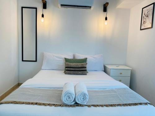 a bedroom with a white bed with towels on it at Serena's 2-BR Apartment in Larnaca in Larnaka