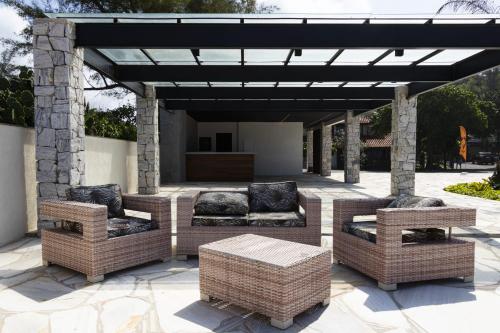 a patio with wicker furniture under a pergola at Deck de Búzios in Búzios