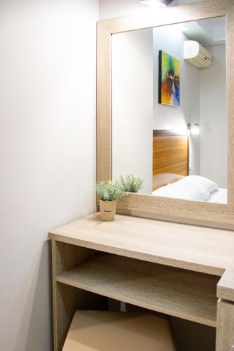 a mirror on a shelf in a bedroom at Hotel Rodon in Paralia Katerinis
