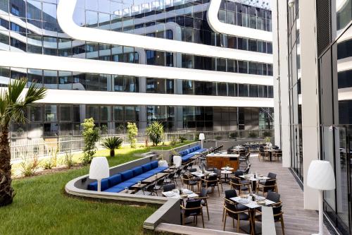 an outdoor patio with tables and chairs in front of a building at Sheraton Nice in Nice