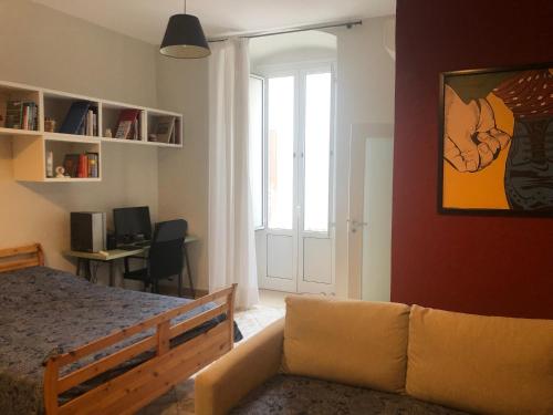 sypialnia z łóżkiem, kanapą i oknem w obiekcie Borghetto Pedale in Town w mieście Terlizzi
