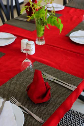 a red table set with silverware and a red napkin at Hotel Neptunia Skanes in Monastir