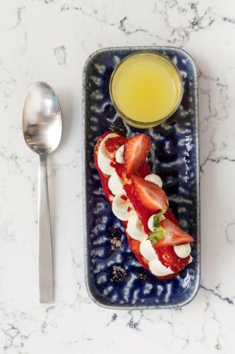 a plate of food with strawberries and a glass of juice at Sheraton Nice in Nice