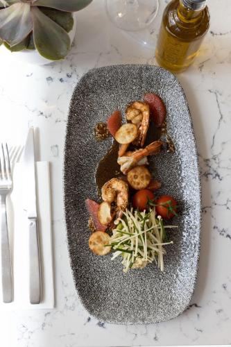 a plate of food with shrimp and vegetables on a table at Sheraton Nice in Nice